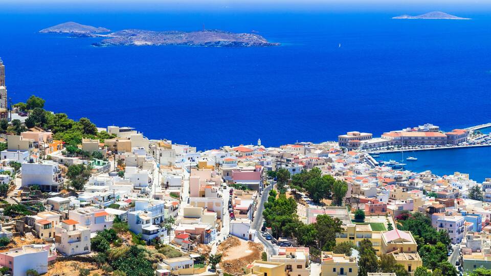 A coastal town with a prominent church, a marina, and a rugged coastline.