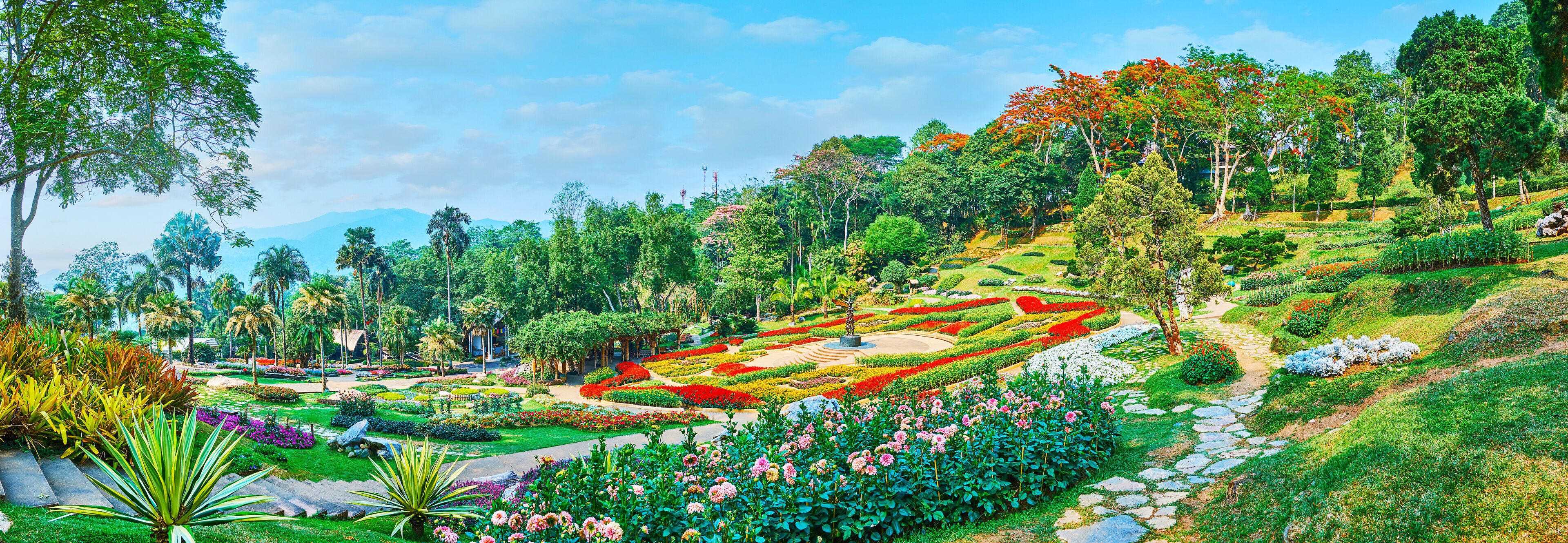 A lush garden with various flower beds and trees.