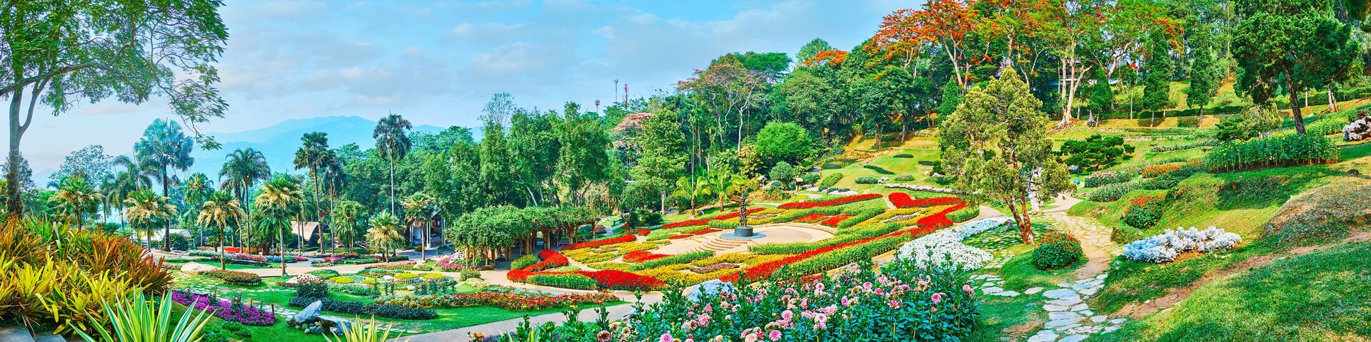 A lush garden with various flower beds and trees.