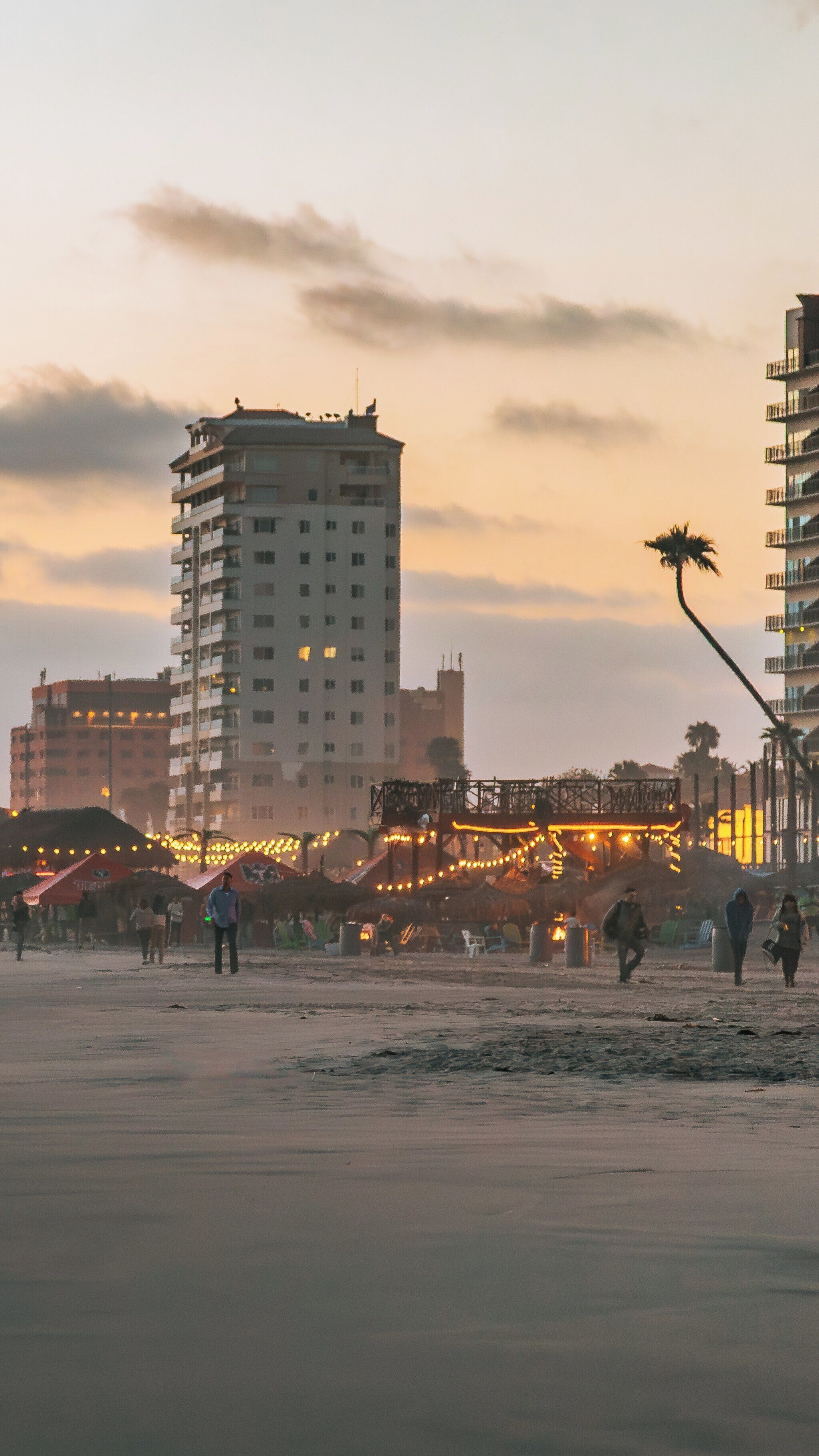 Beautiful sunset view at Rosarito Beach in Centro Playas with evening lights illuminating the waterfront and skyline
