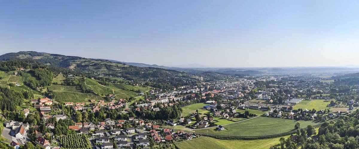 A town nestled in a valley surrounded by hills and forests.