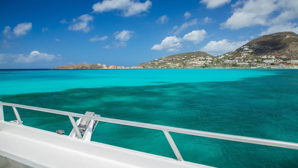 A coastal town with turquoise waters and a mountainous backdrop.