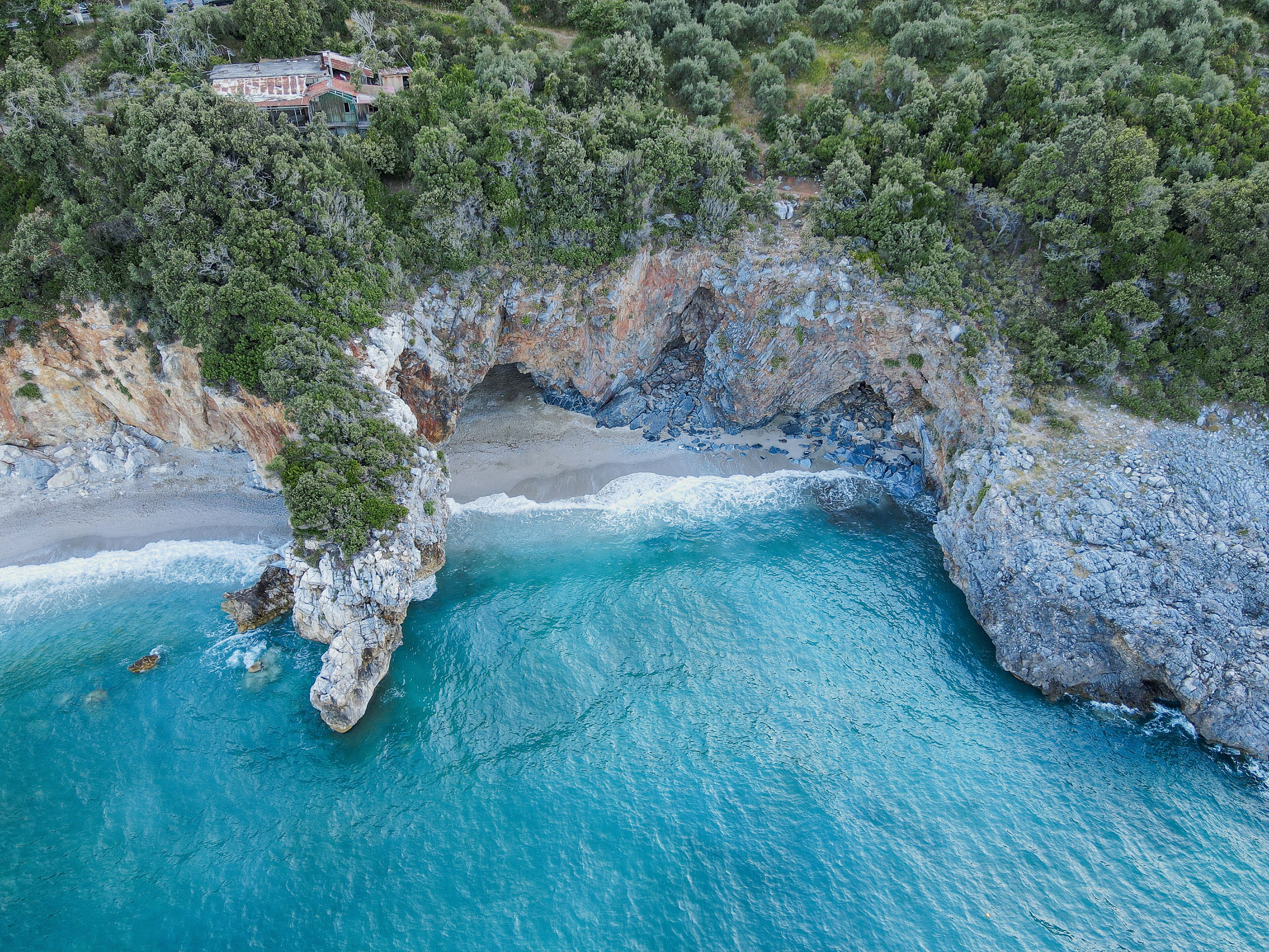Drone top down aerial view of a beach with clear sea water and rocks at Mylopotamos Greece summer_10