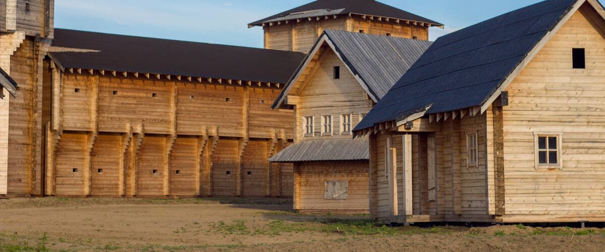 courtyard of an ancient reconstructed wooden fortress with high walls and a tower