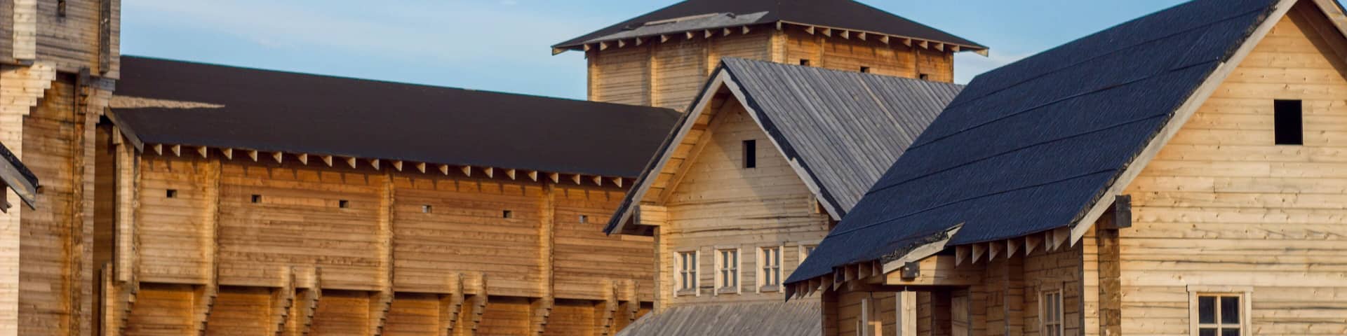courtyard of an ancient reconstructed wooden fortress with high walls and a tower
