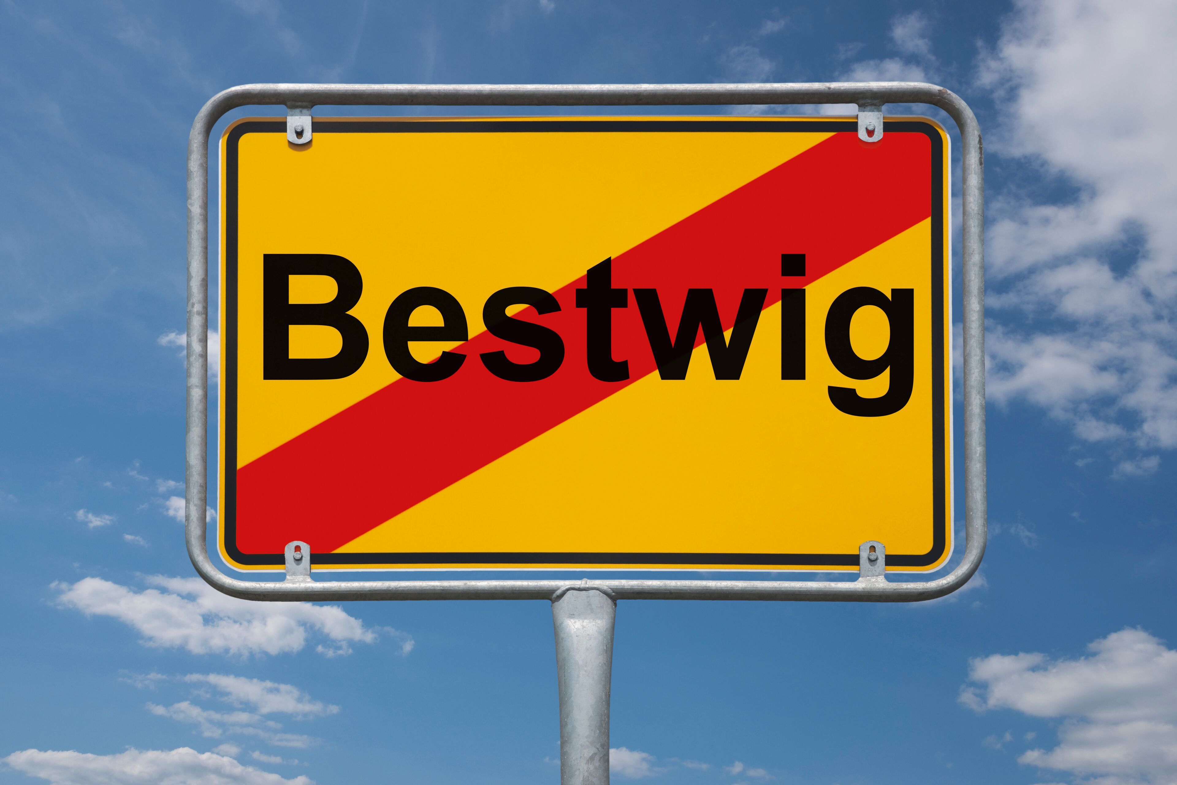A road sign with the word "Bestwig" against a blue sky with clouds.