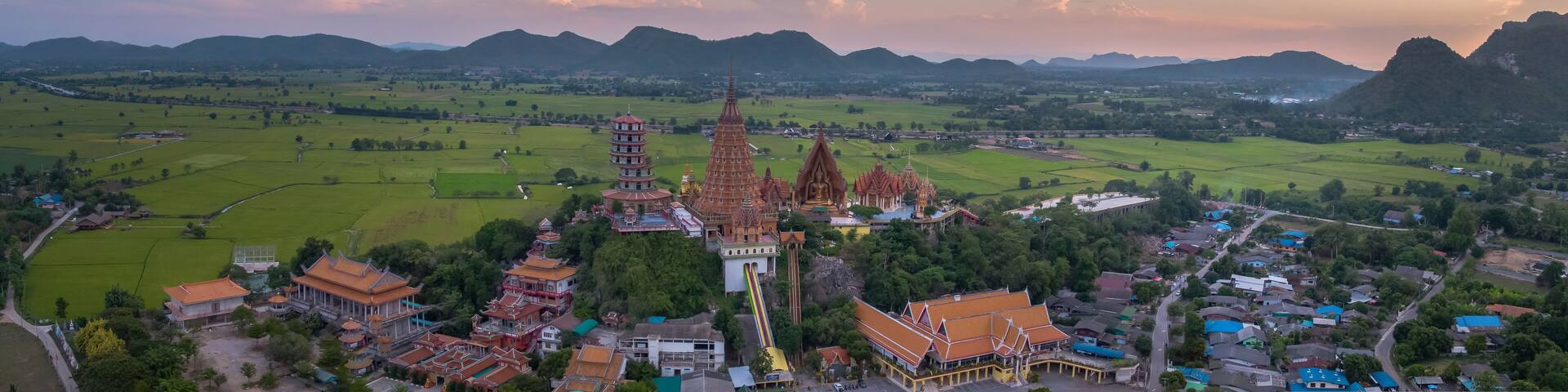 Golden Buddha statue decorated with mosaic inside the semi-circular dome. situated in outdoor area of Wat Tham Sua(Tiger Cave Temple),Tha Muang District,Kanchanaburi,Thailand.