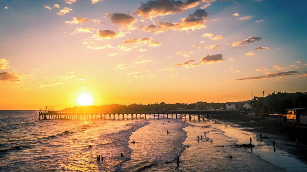 The sun setting behind the pier of La Libertad, in El Salvador.