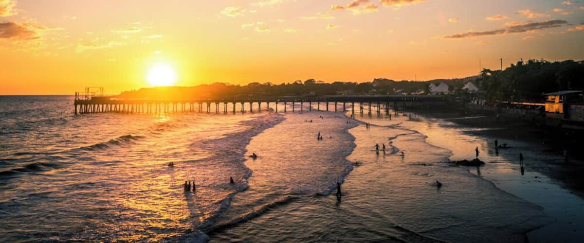 The sun setting behind the pier of La Libertad, in El Salvador.