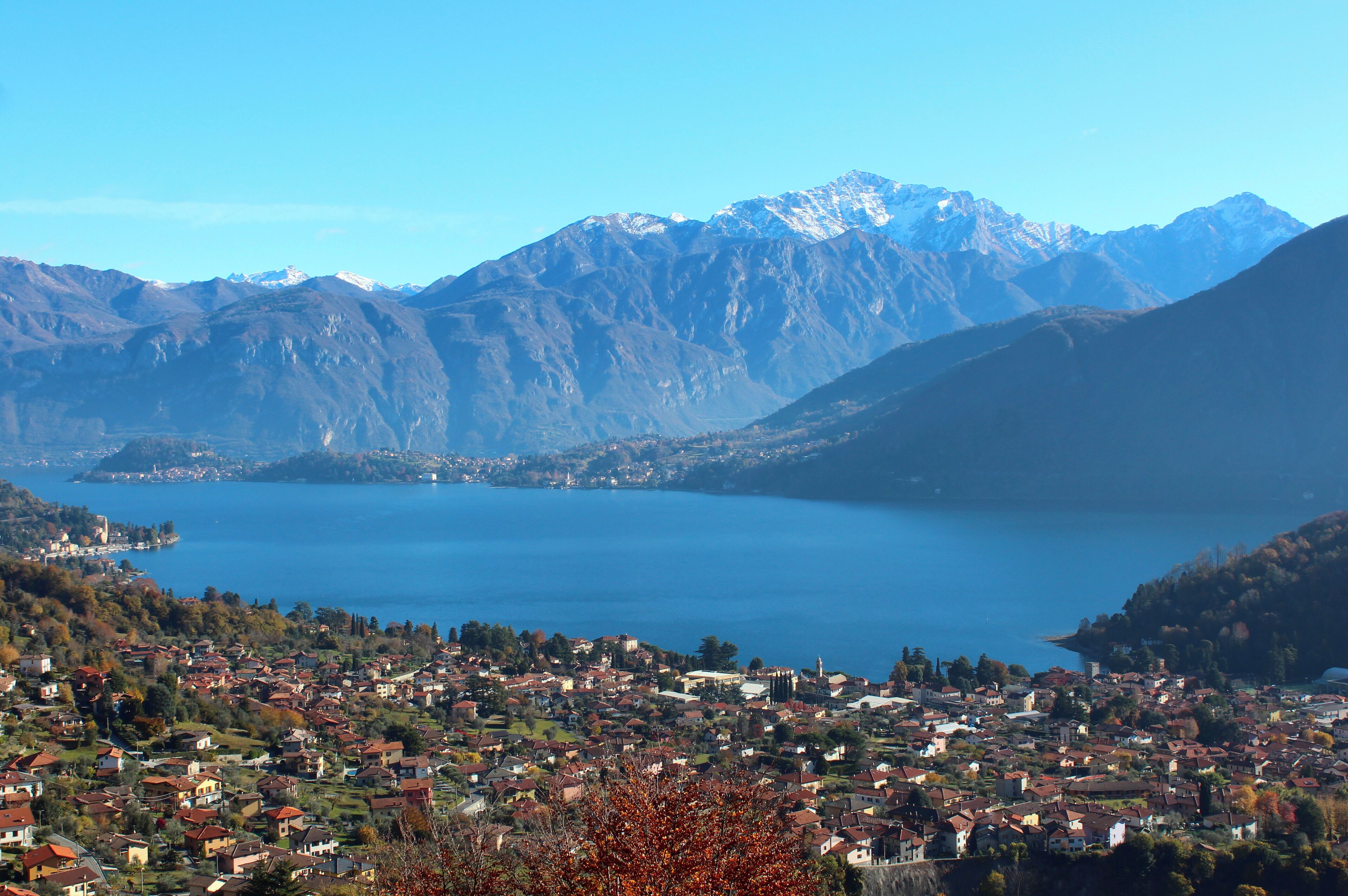 Un paisaje montañoso con un lago y un pueblo en primer plano.