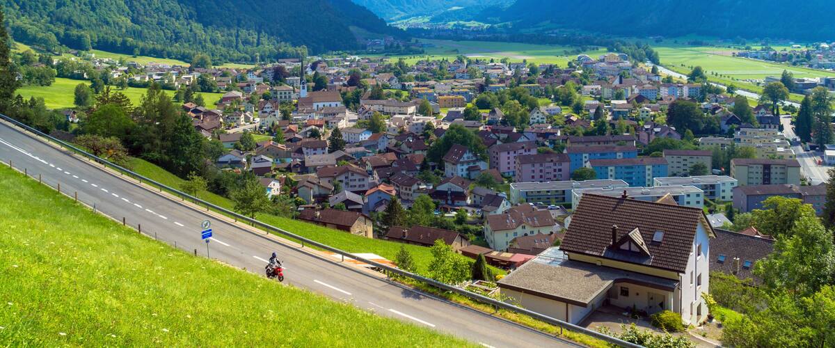 A town nestled in a valley with mountains in the background.
