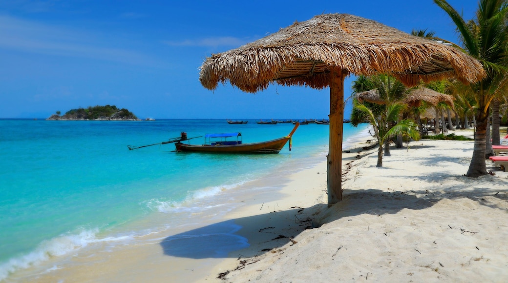long tail boat, in white sand beach in the andaman sea