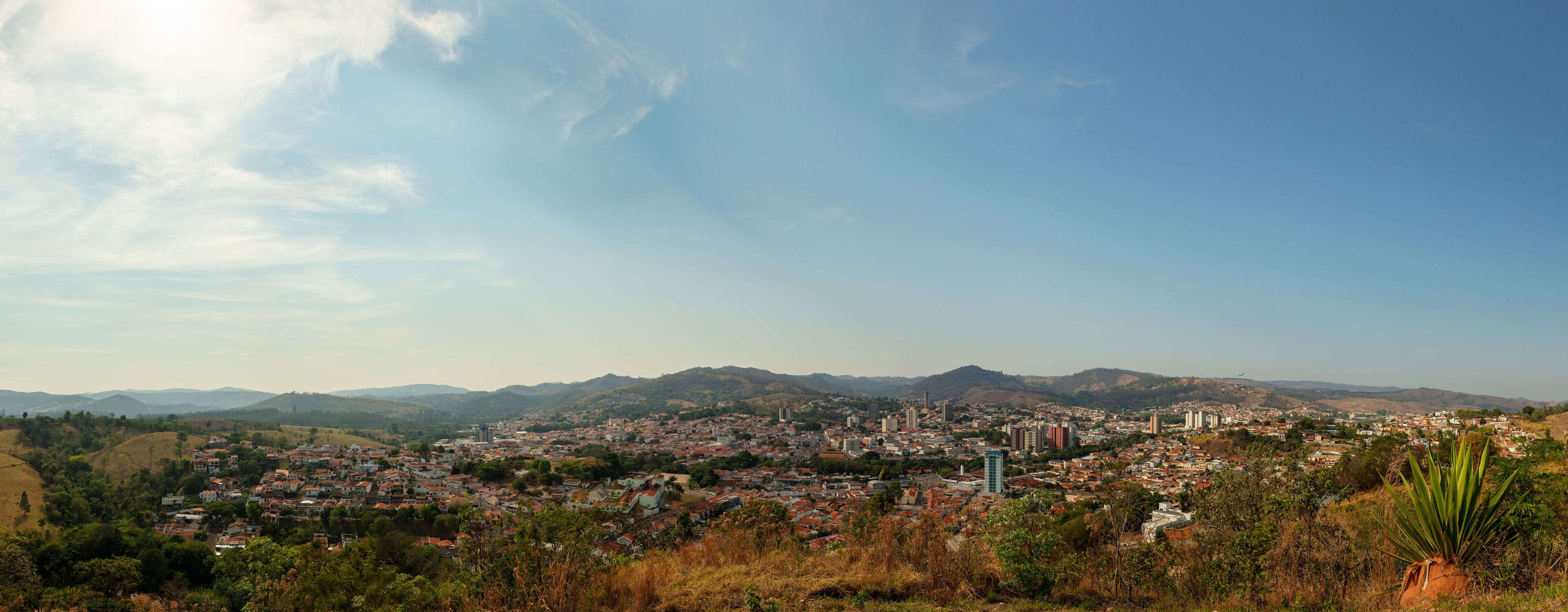 A cityscape with mountains in the background and a clear sky.