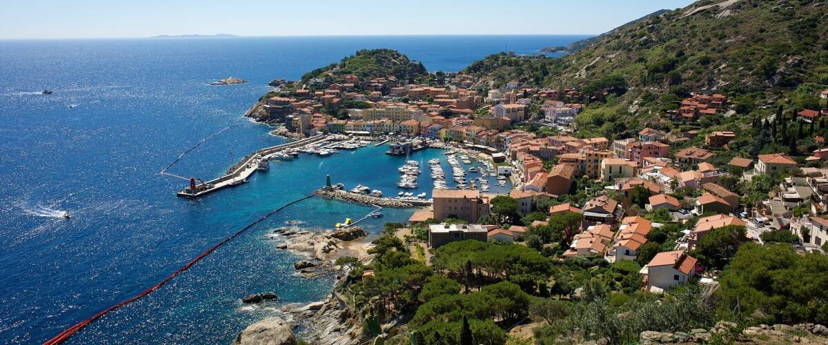 A coastal town with a marina, boats, and buildings.