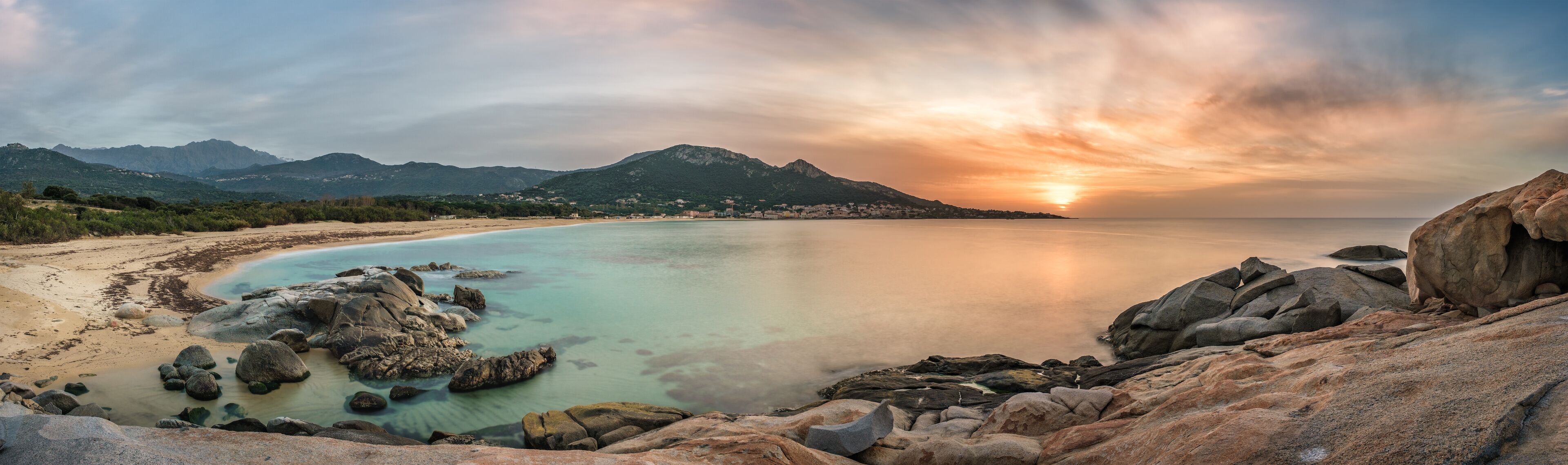 Sunset over beach and village of Algajola in Corsica