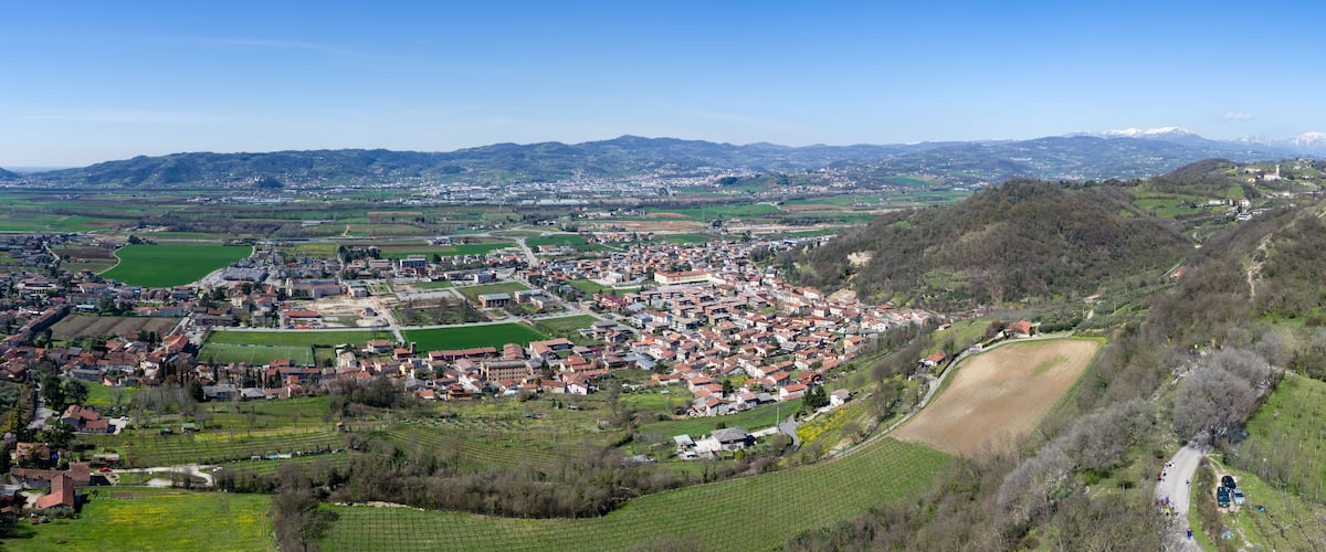 A town nestled in a valley with surrounding hills and fields.