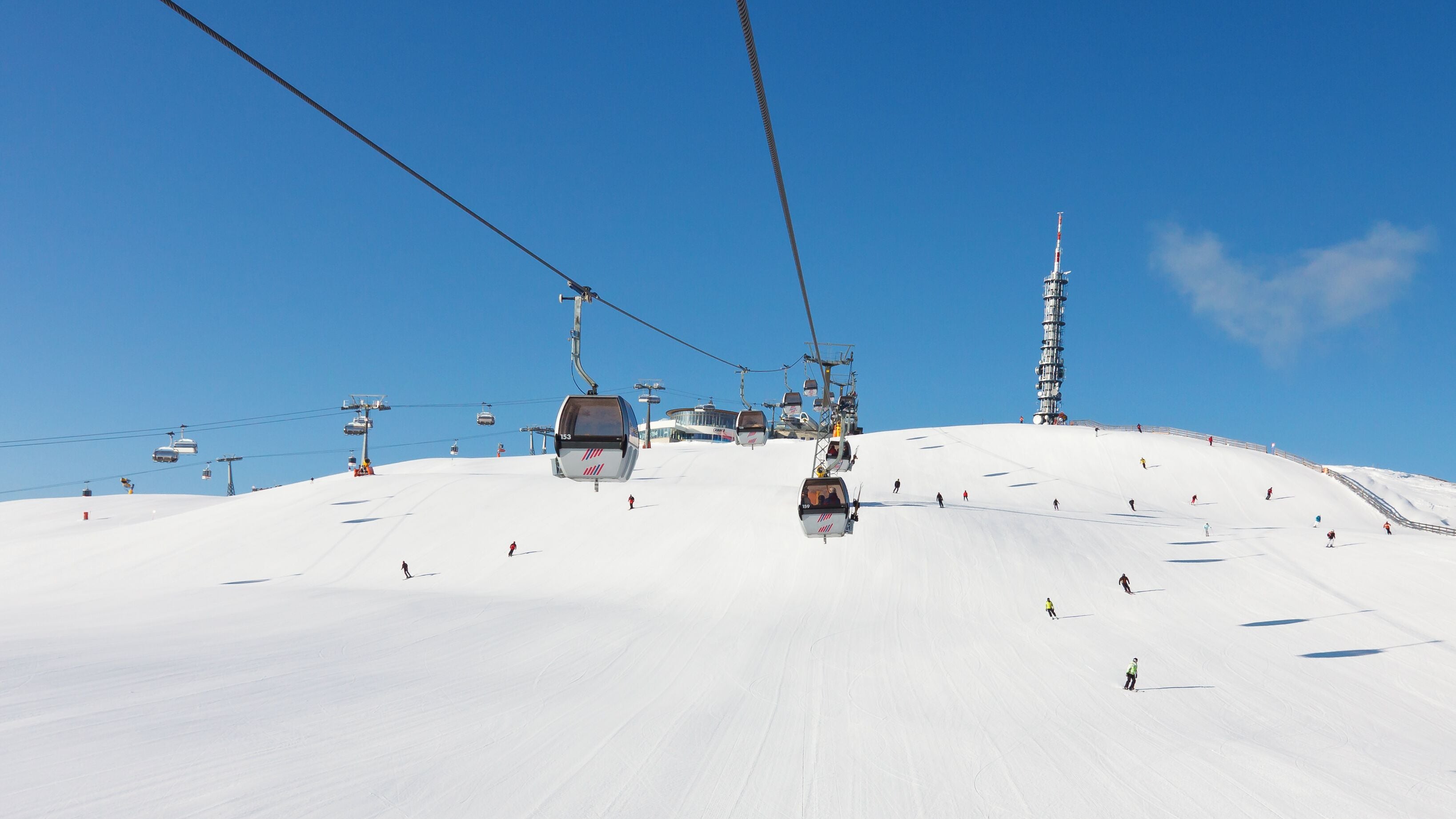 Pista da sci con un sistema di funivia e un'alta torre.