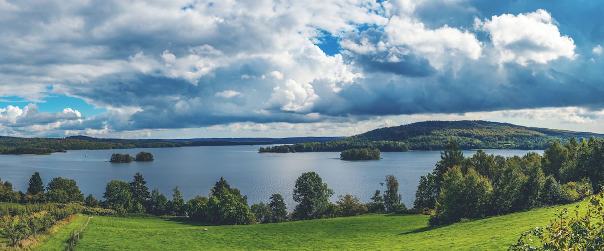 A lake surrounded by green hills and trees.