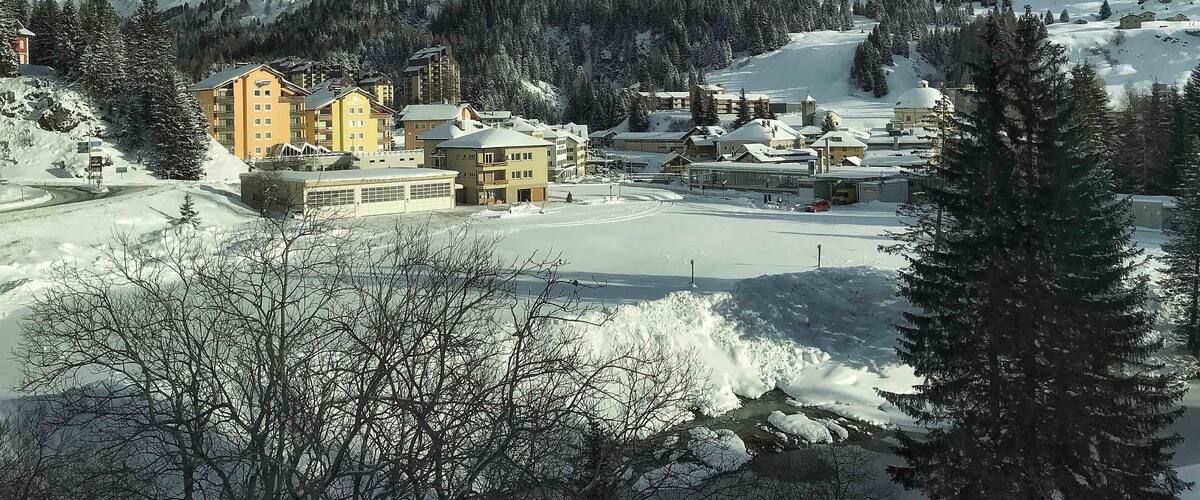 A snow-covered mountain town with buildings and a ski resort.