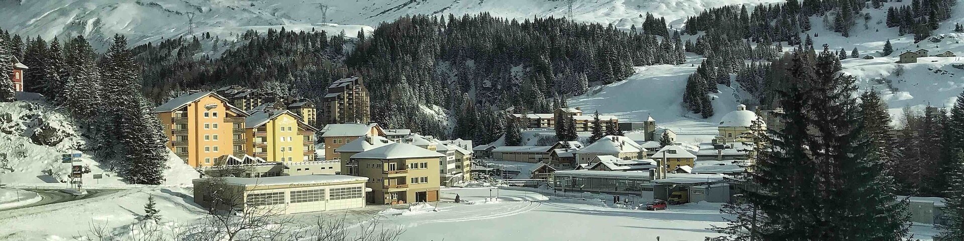 A snow-covered mountain town with buildings and a ski resort.