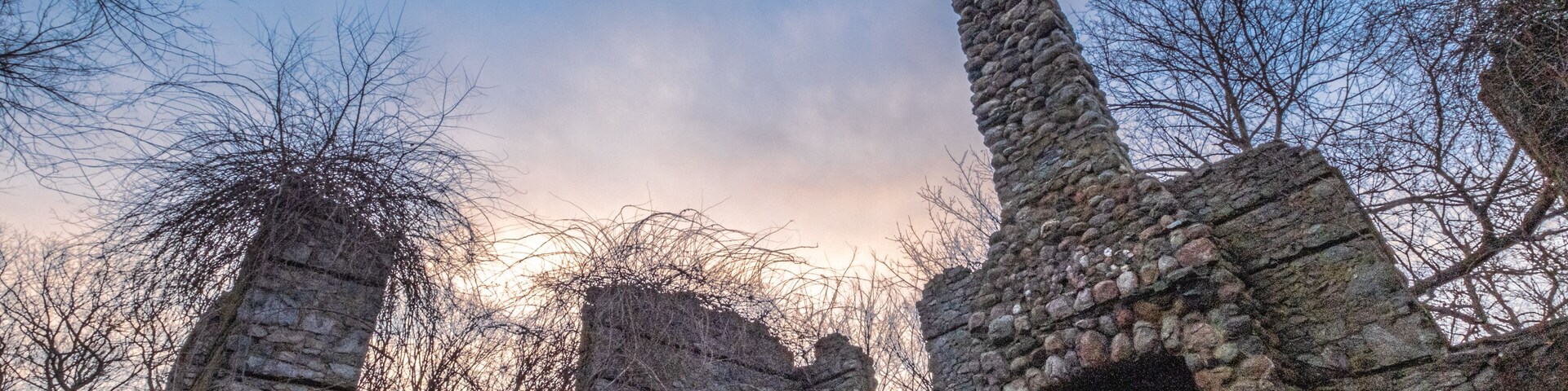 A historic stone ruin with arched doorways and a tall tower.