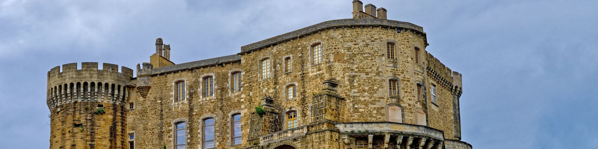 A historic stone castle with a round tower and crenellations.