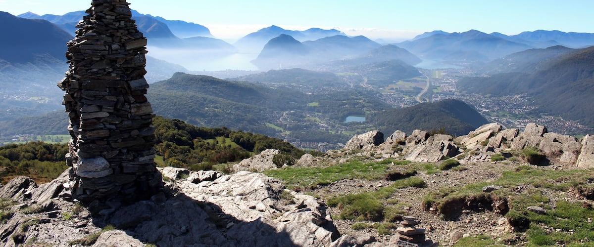 Vom Gipfel des Monte Bigorio (1188m.ü.M.) geht der Fernblick zum Lago di Lugano. Auf der rechten Bildseite sieht man die Orte Bedano, Gravesano, Bioggio und Agno. Daneben verläuft die Autobahn zwischen Milano und Gotthard. In der Bildmitte ist der Lago d'Origlio zu sehen.