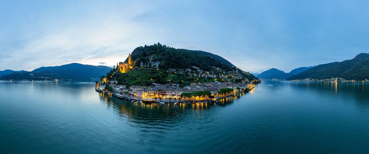 A tranquil lake with a small island featuring a church and residential buildings.