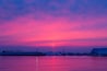 Beautiful pink sunset on the marina yacht harbor with tranquil waves.