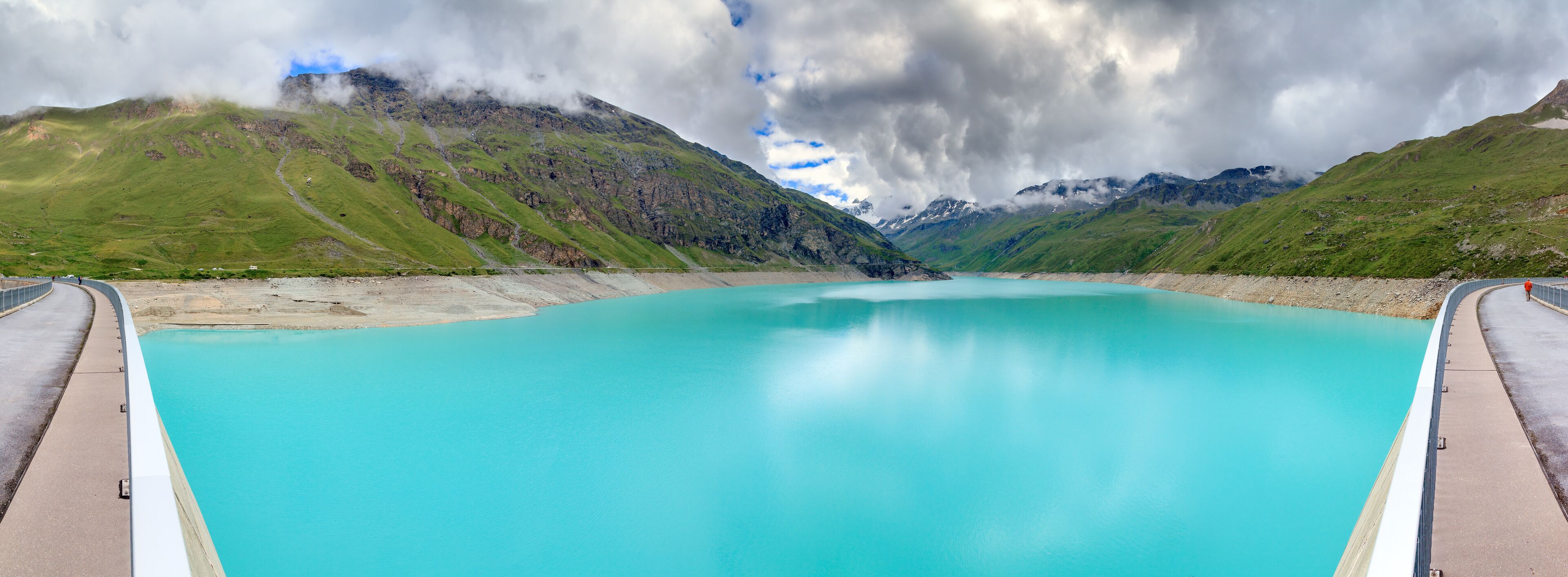 Beautiful 180 degree panoramic view of reservoir lake Moiry (lac de Moiry) with vibrant turquoise blue water at a low level in summer in Valais, Switzerland