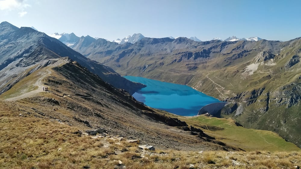 Un paysage de montagne avec un lac turquoise et des pics escarpés.