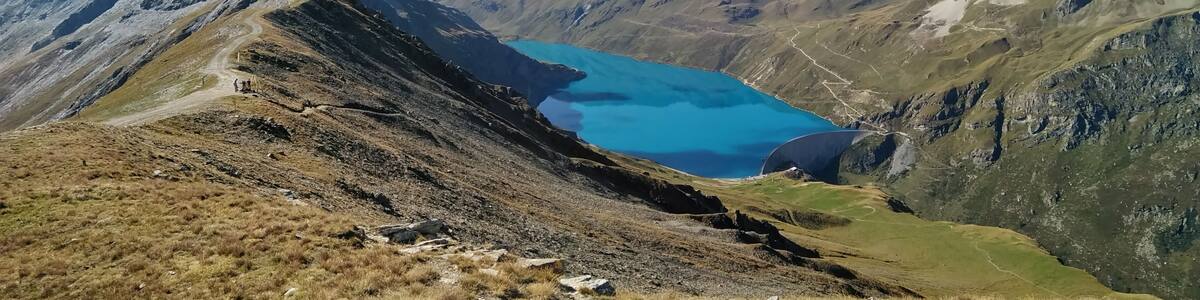 A mountain landscape with a turquoise lake and rugged peaks.