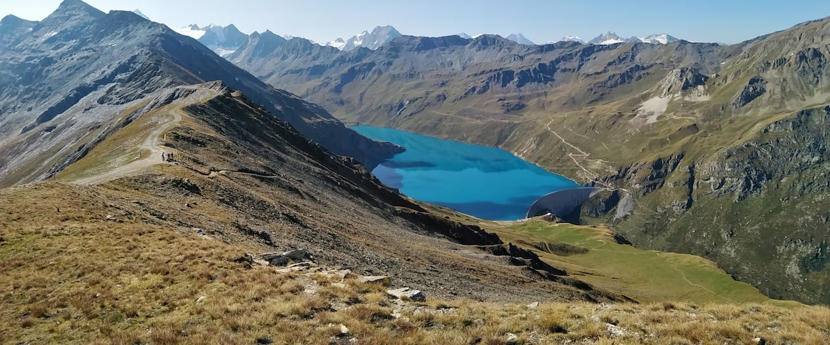 A mountain landscape with a turquoise lake and rugged peaks.