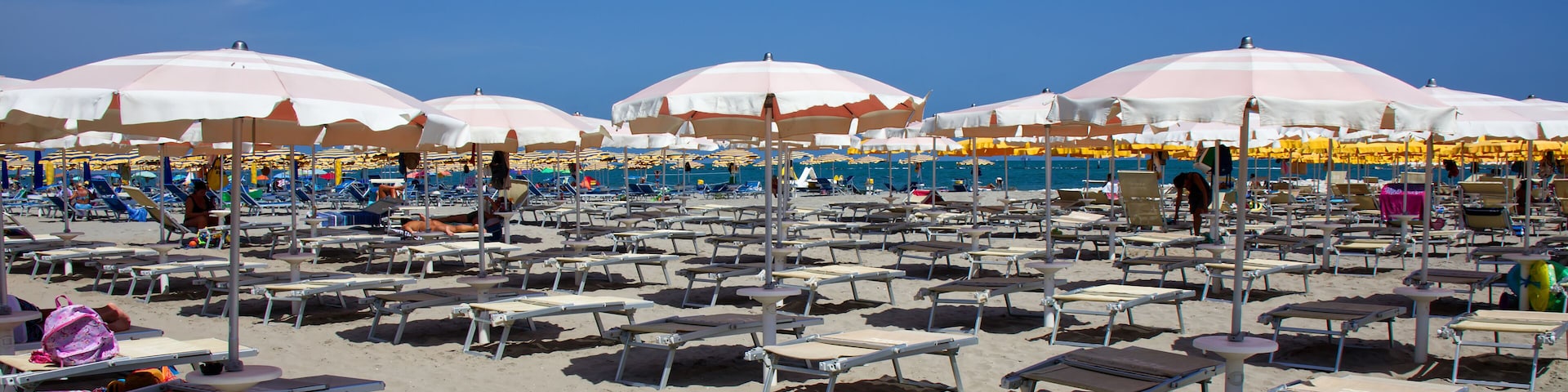 Italian beach view with umbrellas and sunbeds. Summer day on the beach. Riviera Romagnola, Italy
