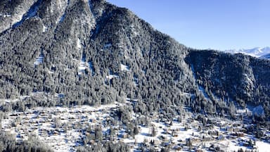 A snow-covered mountain range with a small village nestled at its base.