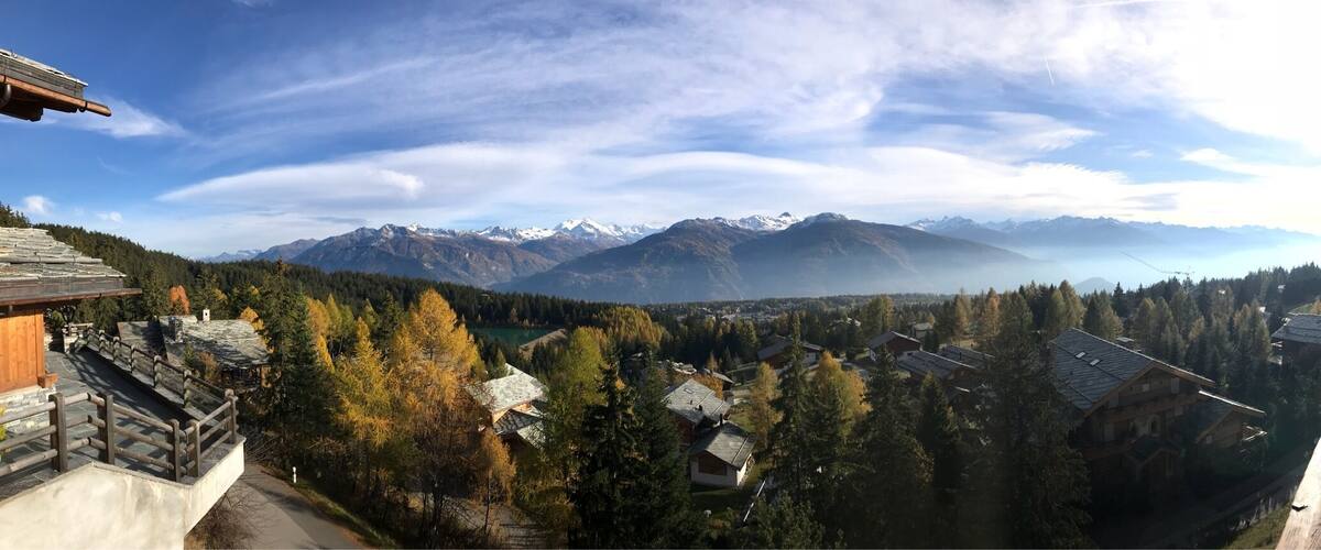 A mountainous landscape with a village nestled among trees.