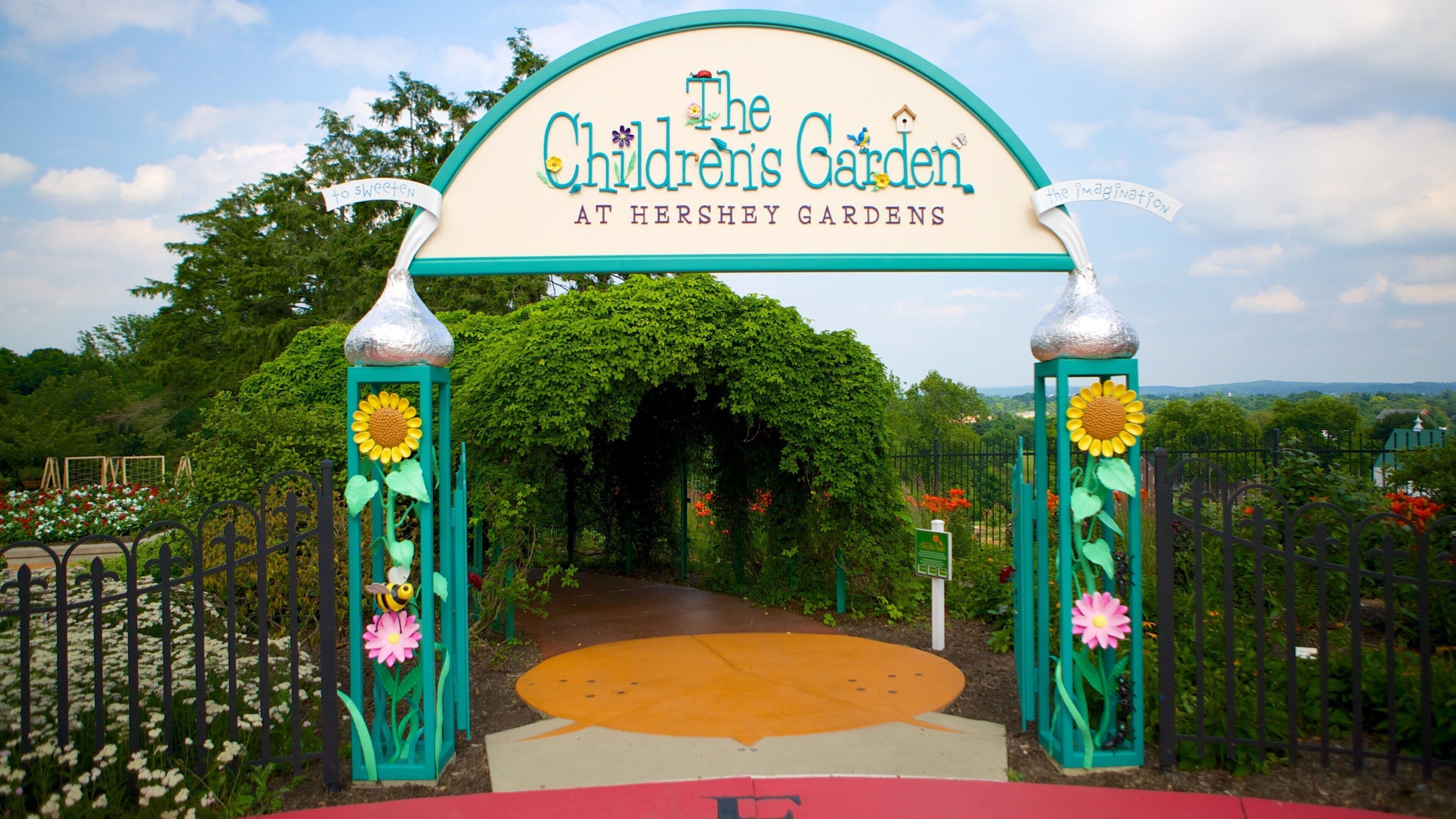 La entrada al Jardín de los Niños en Hershey Gardens, con un arco de girasoles y una escultura de abeja.