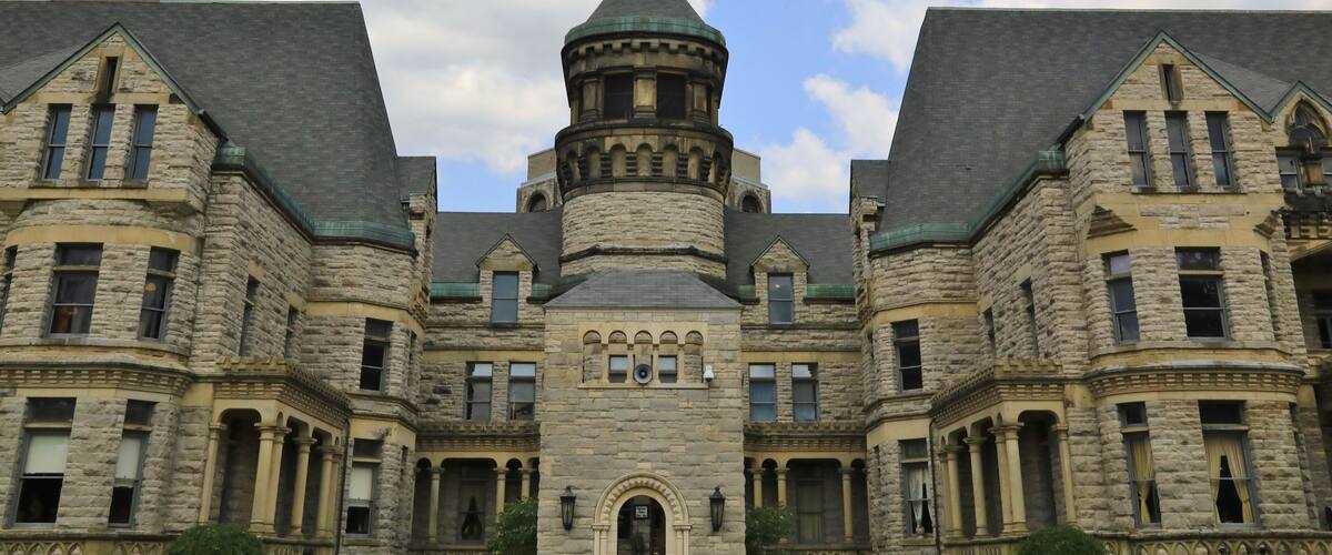A large stone building with a central turret and multiple windows.
