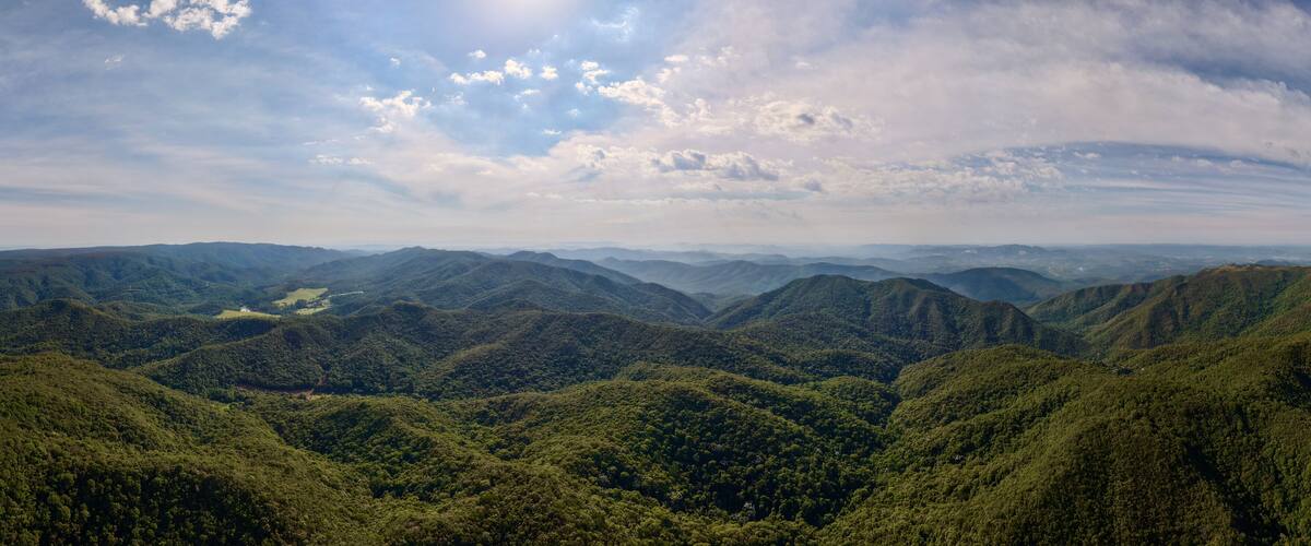 A mountainous landscape with dense forests and rolling hills.