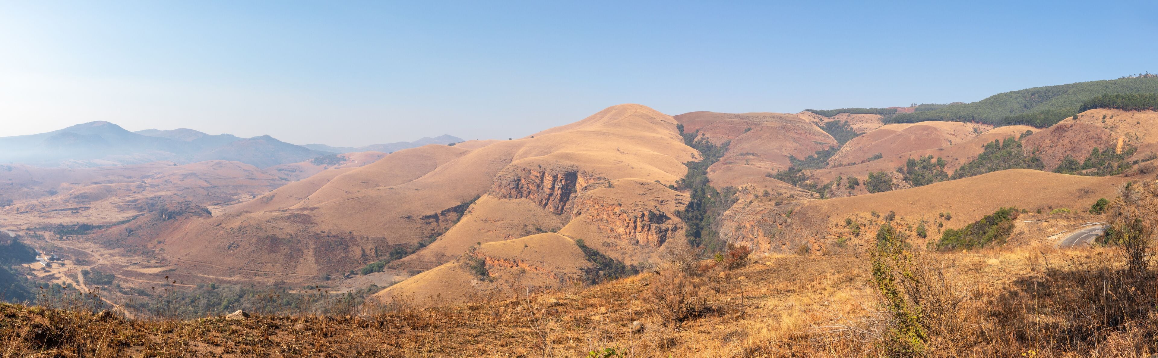 Un paisaje montañoso con colinas ondulantes y cielo despejado.