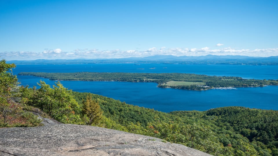 A mountainous landscape with a lake and forested area.