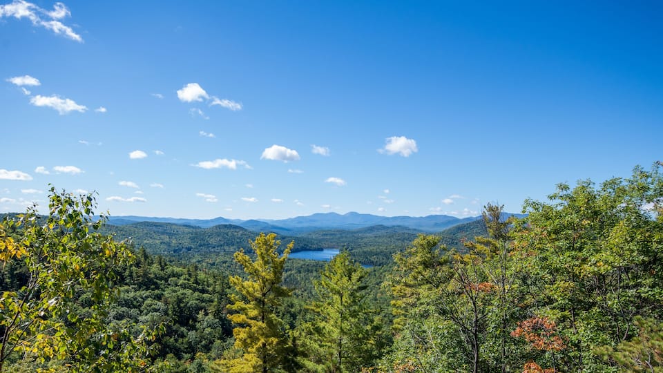 A mountainous landscape with a lake and dense forest.