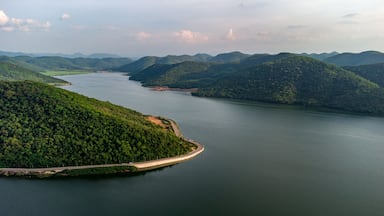 Muak Lek reservoir in Saraburi from aerial bird eye view. Beautiful unseen nature at Muak Lek dam with roadway beside with water and tree hill.