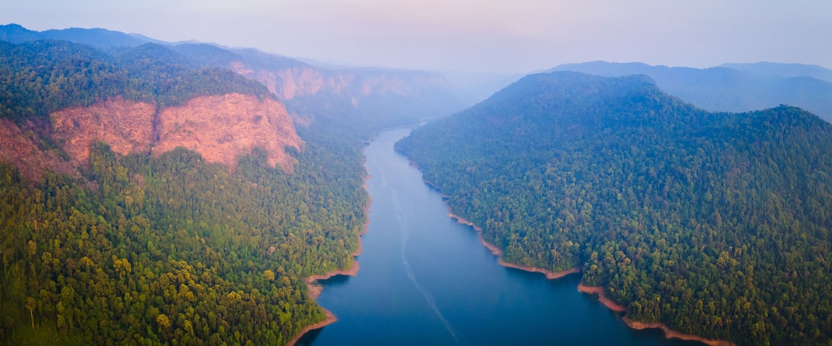 A river winding through a forested valley with mountains on either side.