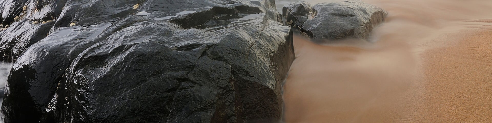 A rocky beach with waves crashing against the shore.