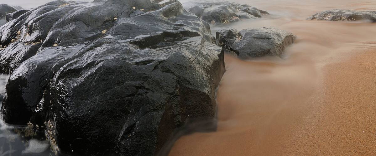 A rocky beach with waves crashing against the shore.