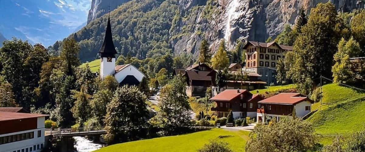 A village with a church, houses, and a waterfall.
