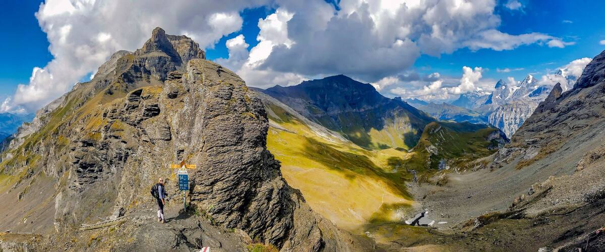 A mountain peak with a person standing on a trail.