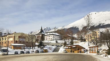 A snowy mountain town with a church, a bus, and a wooden shelter.