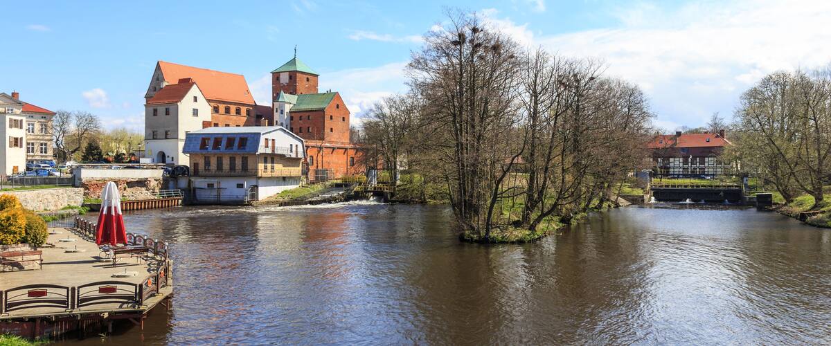 A river with a bridge, a tower, and buildings along the banks.